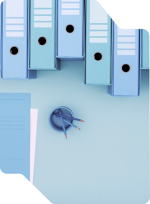 Bild eines Tisches mit Ordnern und Schreibwaren